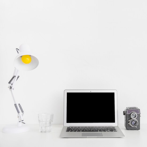 노트북 및 레트로 카메라와 함께 현대적인 흰색 작업 공간