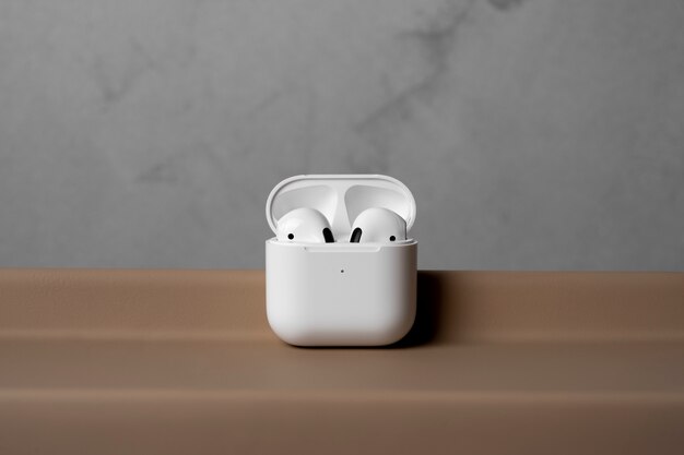 modern wireless earphones with case and simple concrete background
