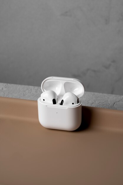 Modern wireless earphones with case and simple concrete background