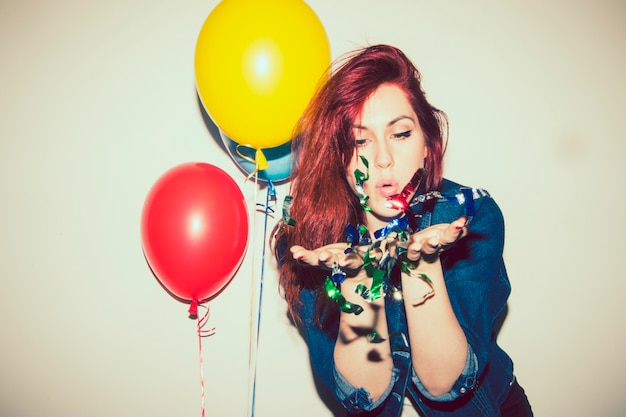 Free photo modern woman celebrating with confetti and balloons