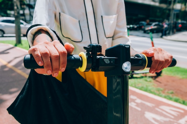 Foto gratuita donna moderna in una città con uno scooter elettrico