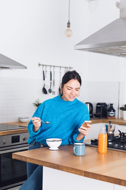 Modern woman having breakfast in the kitchen