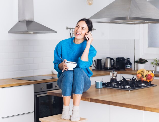 Modern woman having breakfast in the kitchen
