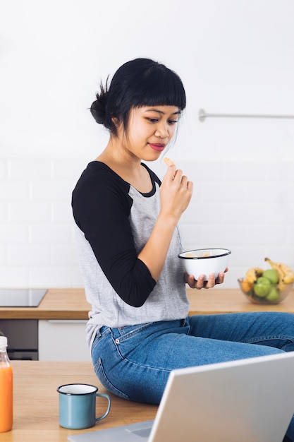 Modern woman having breakfast in the kitchen