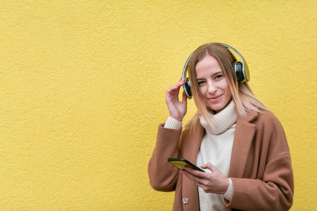 コピースペースとヘッドフォンで音楽を聴く現代の女性