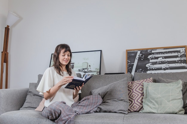 Foto gratuita moderna lettura della donna sul divano