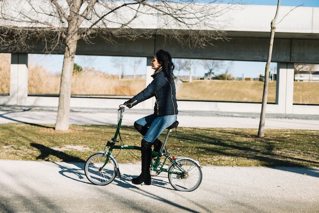 Free photo modern woman riding bike in city