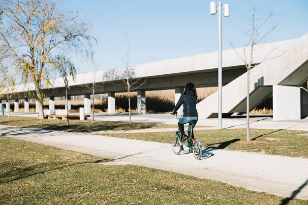 Modern woman riding bike in city