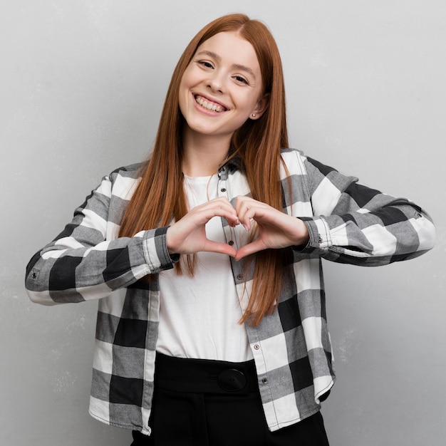 Free photo modern woman showing heart gesture