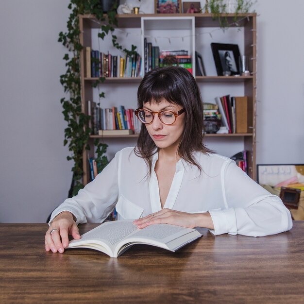 Modern woman with glasses reading a book
