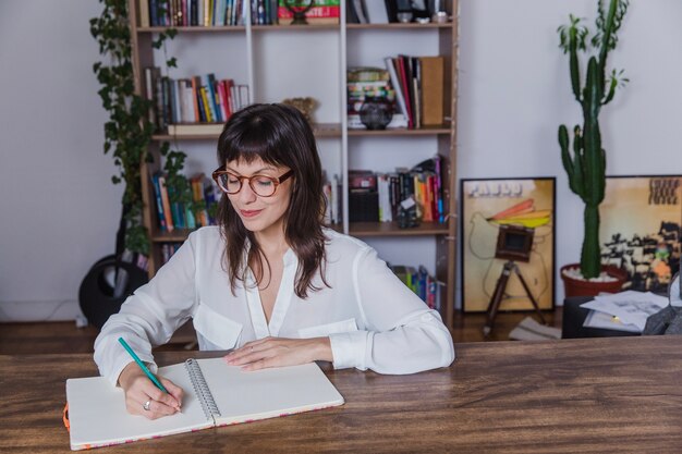 Modern woman with glasses writing