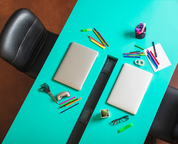 Modern workspace with colorful stationeries and closed laptop