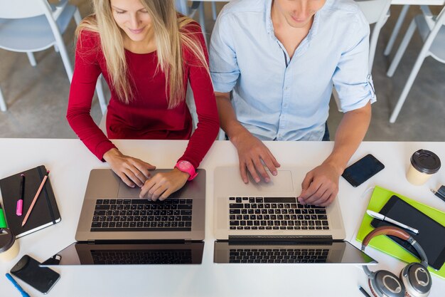 Modern young attractive people working together online in open space co-working office room