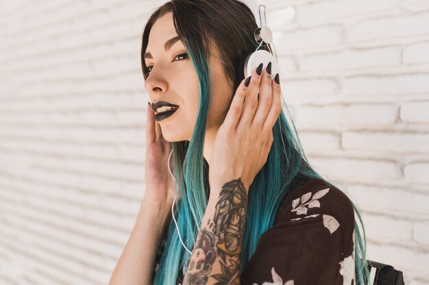 Modern young woman listening music on headphone