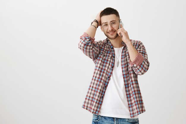 Modest handsome young guy posing with his phone