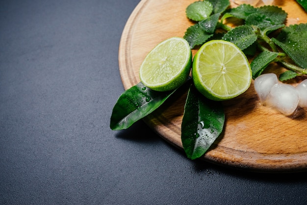 Mojito cocktail making. Mint, lime, lemon ice ingredients and bar utensils.