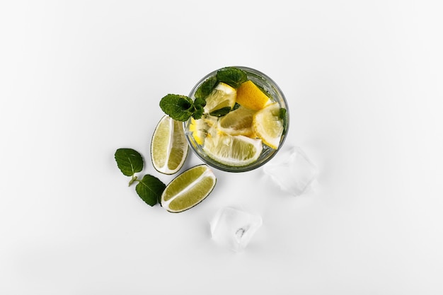 Коктейльный напиток Mojito в спиртовом бокале с газированной водой, лимонным соком лимона