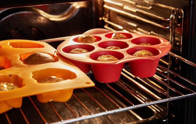 Molds with ready-made baked muffins with sun-dried tomatoes in the oven.