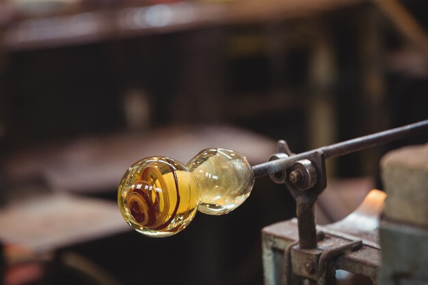 Molten glass on blowpipe on marver table