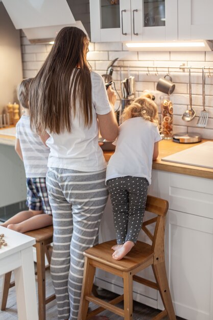 ママと娘は、自宅のキッチンでジンジャーブレッドのアイシングを準備します。 Premium写真
