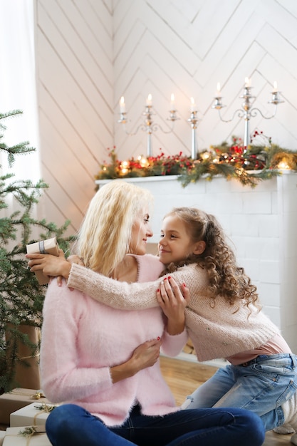 Free photo mom and daughter in christmas-decorated living room