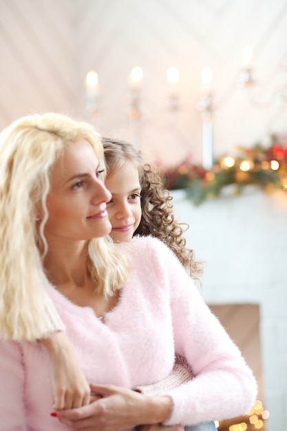 Mom and daughter in Christmas-decorated living room