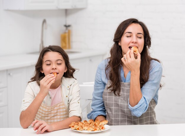 ママと娘が一緒にいくつかのペストリーを食べる