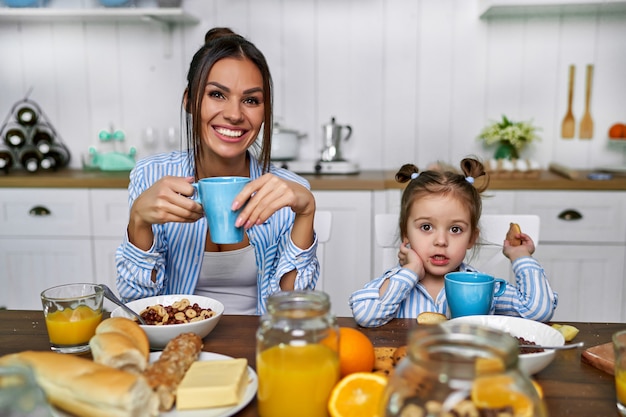 Mom and daughter have breakfast in the morning at home