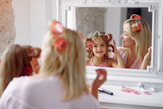 Mom and daughter at home with curlers on their heads
