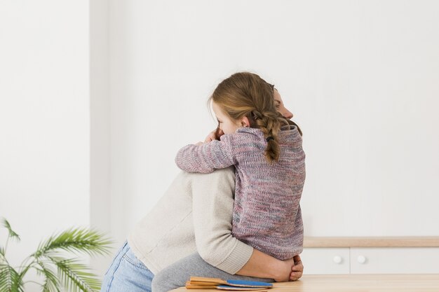 mom and daughter hugging side view