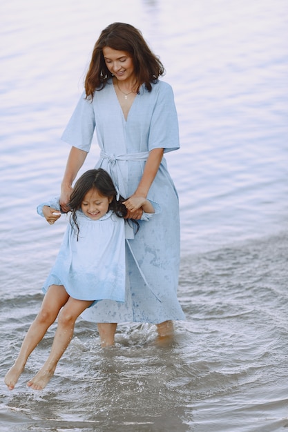 Foto gratuita mamma e figlia in abiti identici. famiglia che gioca in riva al fiume.