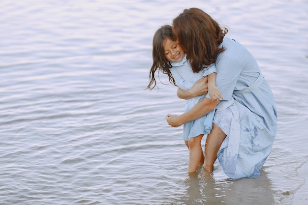 Foto gratuita mamma e figlia in abiti identici. famiglia che gioca in riva al fiume.