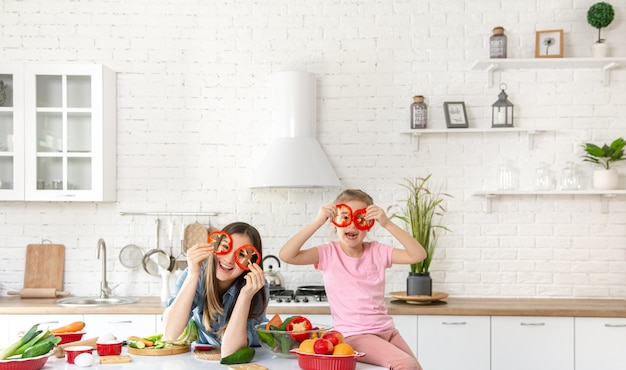 Foto gratuita mamma e figlia preparano un'insalata in cucina.