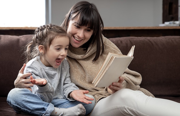 Mom and daughter spend time together reading a book. The concept of children's development and quality time.