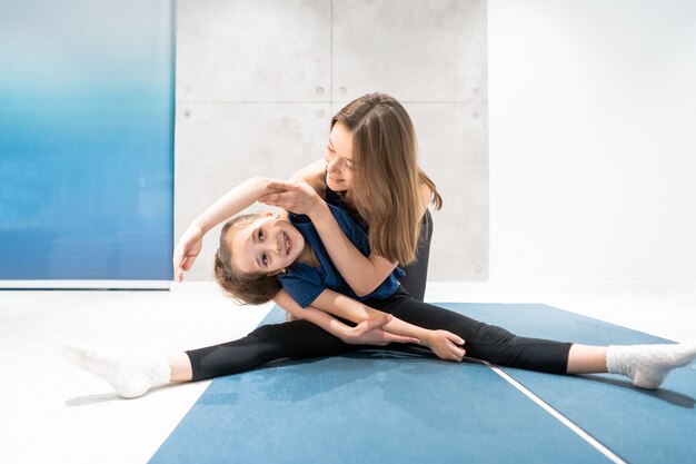 Mom and daughter do stretching before exercise