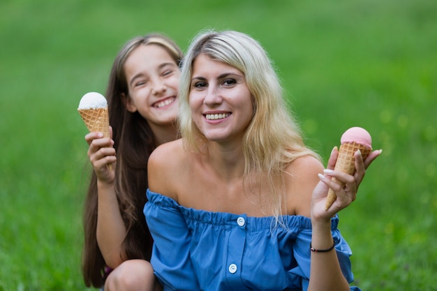 Мама и дочка с мороженым в парке
