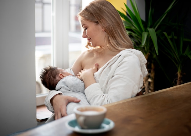 Free photo mom gently breast feeding her child