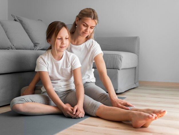 Mom and girl on mat stretching