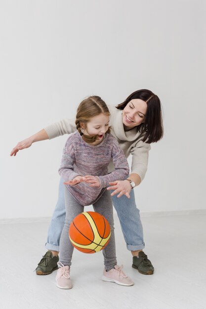 Mom and girl playing basketball