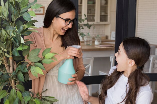 Mom and girl watering plant