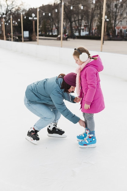 Free photo mom helping cute daughter full shot