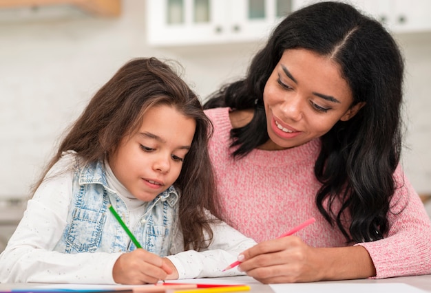 Мама помогает дочери с домашними заданиями