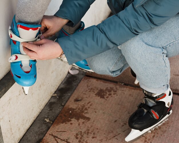 Mom helping daughter with ice skates