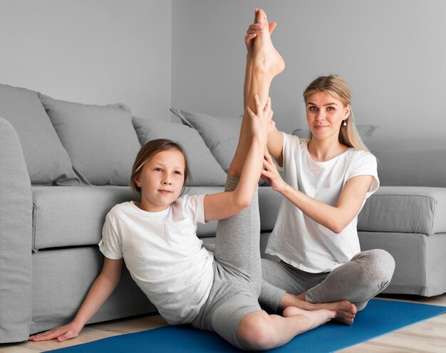 Mom helping girl to stretch