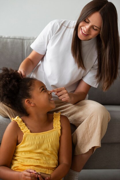 子供がアフロヘアをスタイリングするのを手伝うママ