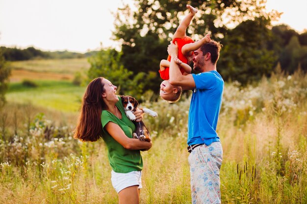 Mom holds little poppy while dad stands with son turned upside down 