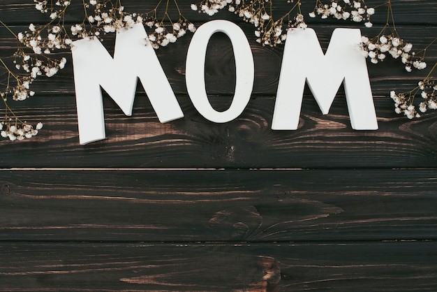 Free photo mom inscription with flower branches on table