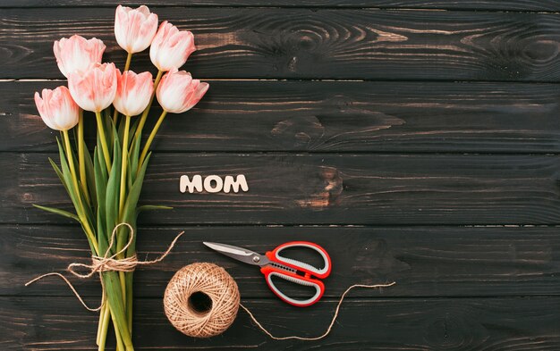 Мама надпись с букетом тюльпанов на темном столе