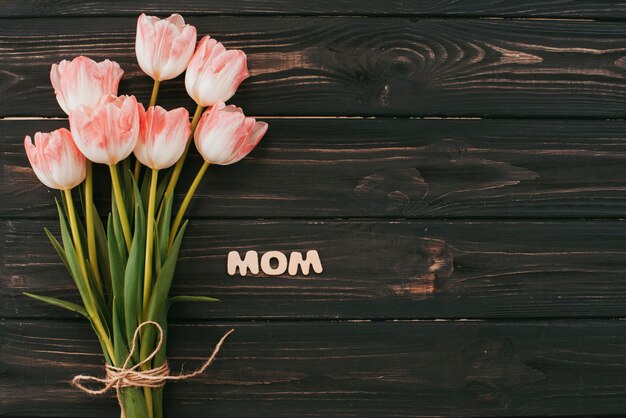 テーブルの上のチューリップ花束とママの碑文