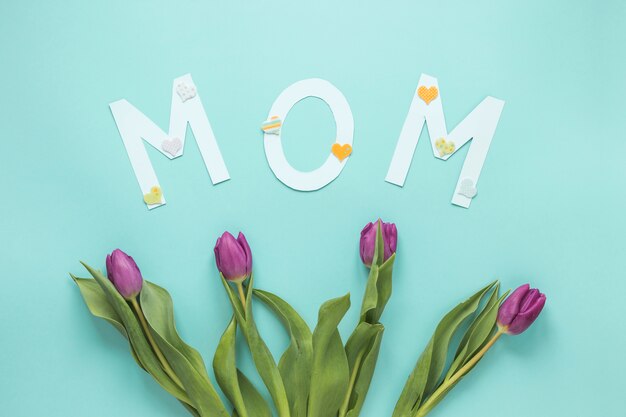 Mom inscription with tulips on table